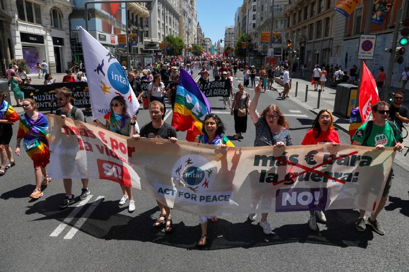 数千人周日走上西班牙首都马德里街头，有人举着旗帜和标语，抗议将在那里举行的北约峰会